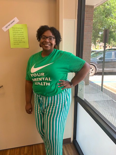 Shelbi Lewis, counselor at the New Season Biloxi Treatment Center, proudly represents mental health awareness by wearing a custom shirt supporting the cause.